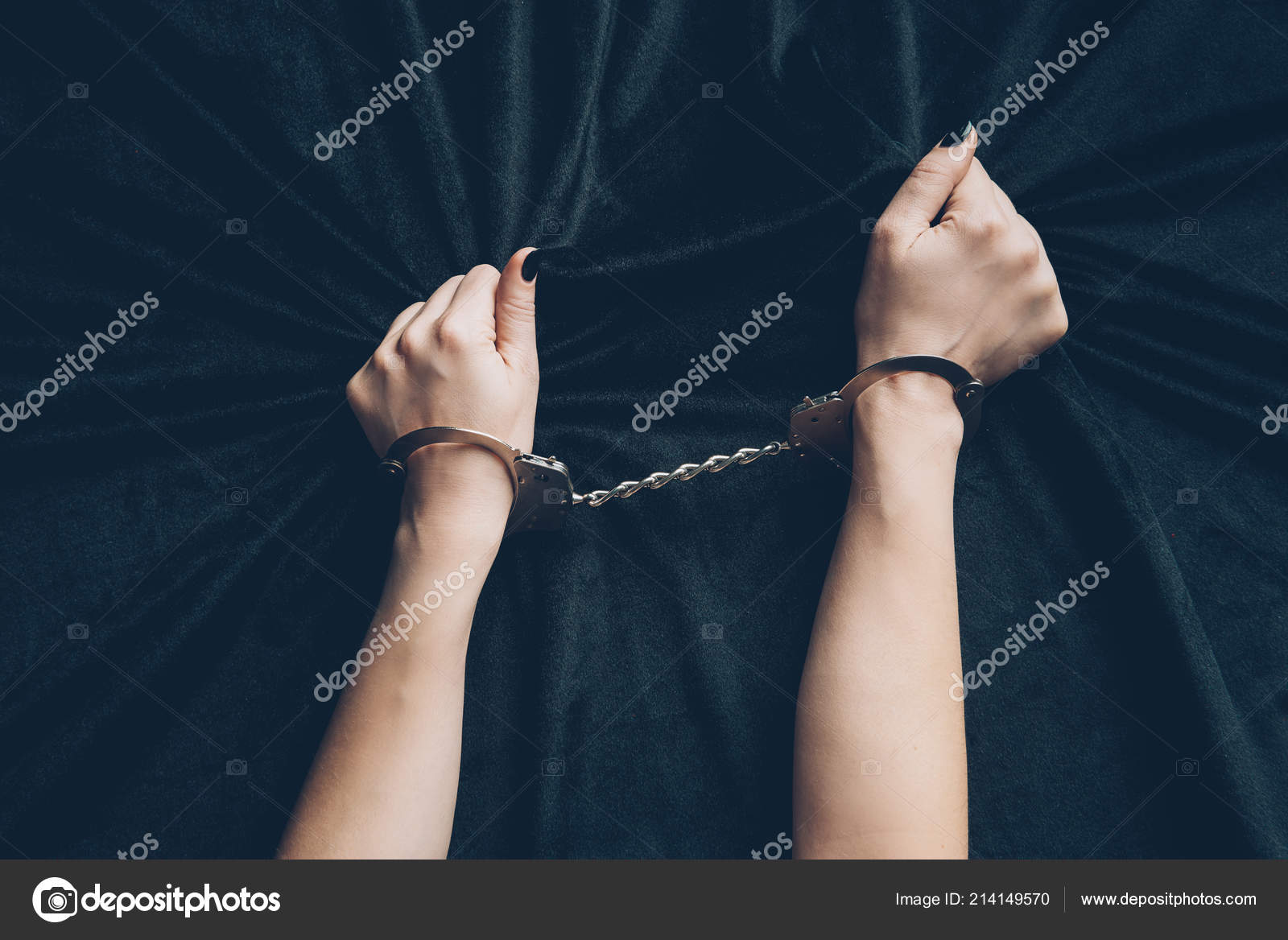 Раздетая длинноногая брюнетка крепко держит наручники в руке