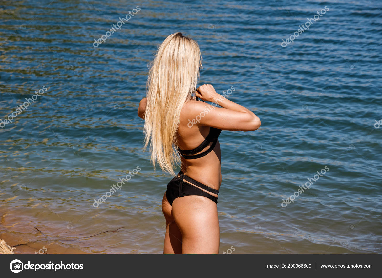 Блондинка в чёрном купальнике ходит по полю фото