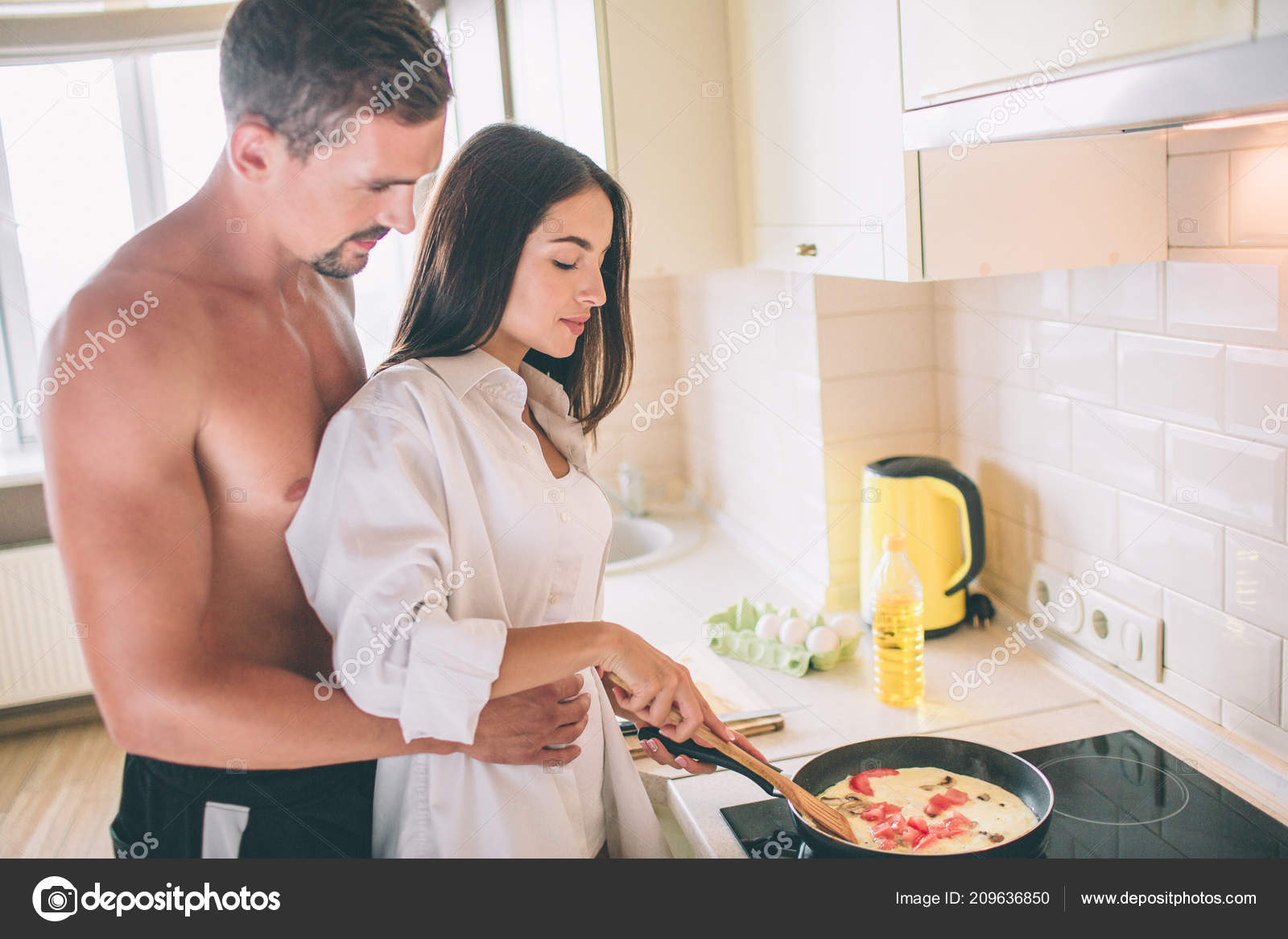Раздетая девушка готовит ужин на кухне