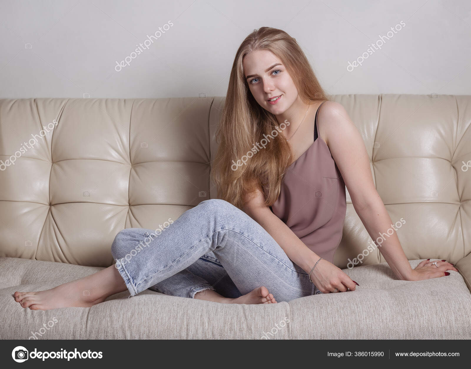 У блондинки с длинными волосами сидящей на диване большой клиторок