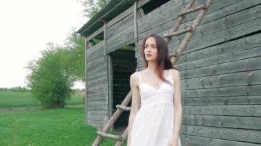 bahar moda ahşap depo yakınındaki uzun kahverengi saçlı beyaz elbiseli güzel mutlu bir genç kadın portresi