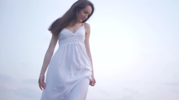 Ihale şehvetli bahar moda portre güzel bir mutlu genç kadının beyaz elbiseli mavi gökyüzü arka planda uzun kahverengi saçlı — Stok video
