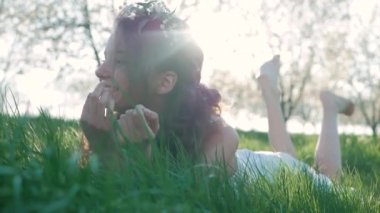 Güzellik gülümseyen kız bahar çayır kır çiçekleri ile yalan. Gülmek ve mutlu. Doğa keyfini çıkarın. Güzel genç kadın açık havada.