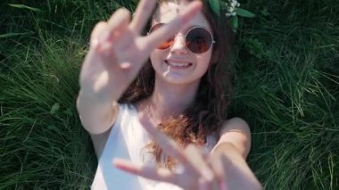 Yavaş hareket: bir beyaz kız beyaz çiçek çim yalan elbise ve barış işareti gösterir görünümü Top