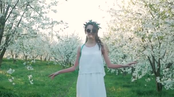 Dívka chůze na rozkvetlé zahrady a odpočinek — Stock video