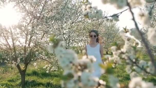 Beleza jovem apreciando a natureza no pomar de maçã primavera, menina bonita feliz no jardim com árvores florescentes — Vídeo de Stock