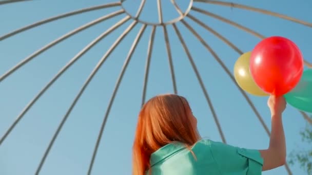 Schoonheid meisje met rood haar en kleurrijke lucht ballonnen spinnen en lachen, op witte achtergrond. Mooie gelukkig jonge vrouw op vakantie verjaardagsfeestje. Vrolijke model plezier, vieren — Stockvideo