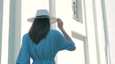 Mutlu şık büyüleyici genç yarış kadın moda Blogger yürüyüş boyunca Avrupa kentsel mavi yazlık elbise sokakta karışık ve beyaz şapka ve zevk tatil tatil macera seyahat