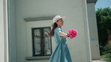 Mutlu şık büyüleyici genç yarış kadın moda Blogger yürüyüş boyunca Avrupa kentsel mavi yazlık elbise sokakta karışık ve beyaz şapka ve zevk tatil tatil macera whith pembe çiçekler seyahat
