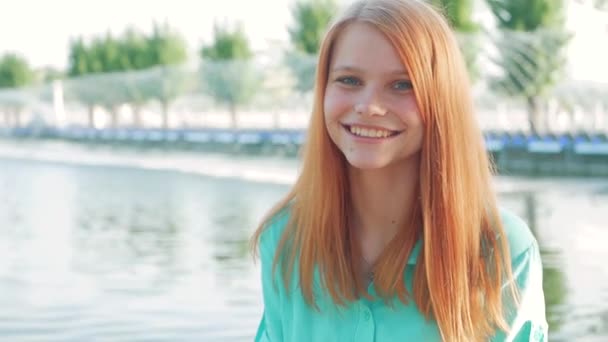 Portret van een jonge mooie vrouw met rood haar in een park in het voorjaar — Stockvideo