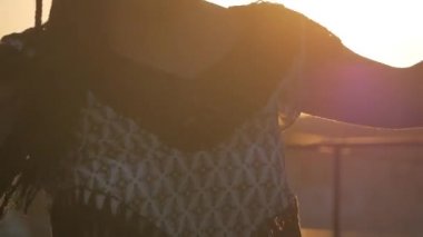 Erkek dans. siluet mutlu karışık ırk kadın uzun dreadlocks ile performans şortla günbatımı arka plan üzerinde dans.