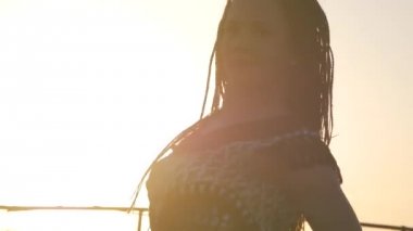 Erkek dans. siluet mutlu karışık ırk kadın uzun dreadlocks ile performans şortla günbatımı arka plan üzerinde dans.