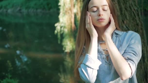 Ember és természet. gyönyörű fiatal nő élvezi egység a természettel, ül egy fa folyó — Stock videók