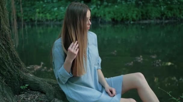 Человека и природу. красивая молодая женщина наслаждается единством с природой сидя на дереве реки — стоковое видео