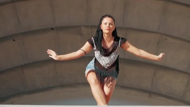Tanzende Frau. fröhliche Mischlingshündin tanzt Performance mit langen Dreadlocks in kurzen Hosen — Stockvideo