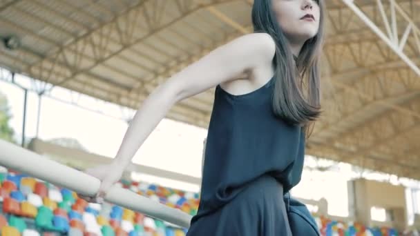 Siyah, deri ceket, uzun siyah saçlı ve ruj ile gerdanlık kolye giyen serin moda ciddi genç kadın — Stok video