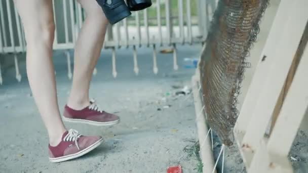 25. Mai 2018: Ein Mädchen tritt gegen ein Metallgitter. Fokus auf Beine in roten Turnschuhen — Stockvideo