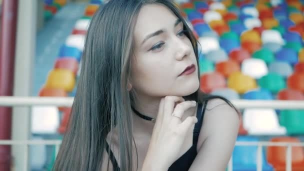 Cool moda seria adolescente indossa in nero, giacca di pelle, collana girocollo con lunghi capelli scuri e rossetto — Video Stock