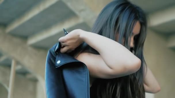 cool mode grave adolescent femme portant en noir, veste en cuir, collier étrangleur avec un long cheveux foncés et rouge à lèvres 