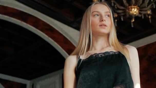 时尚肖像的一个美丽的年轻女子蓝色的眼睛和金发在皮革夹克室内 — 图库视频影像