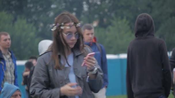 UKRAINE, TERNOPIL - 20 de julho de 2018: hippie menina com telefone nas mãos e óculos de sol dançando no festival — Vídeo de Stock