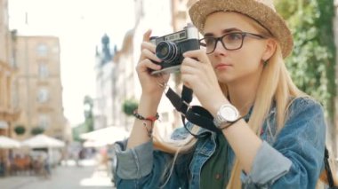 Genç kadın turist tatile bir şehir retro kamerada fotoğraf çekimi