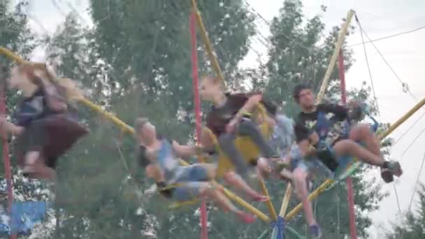 UKRAINE, TERNOPIL - 20 juillet 2018 : Meilleurs amis adolescents heureux chevauchant le carrousel de chairoplane et s'amusant à la fête foraine — Video