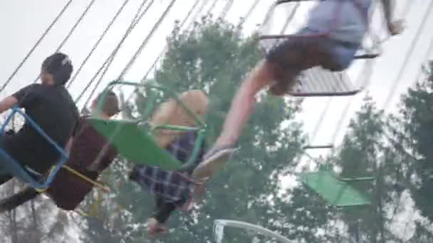 Feliz adolescente melhores amigos montando o carrossel chairoplane e se divertindo na feira — Vídeo de Stock