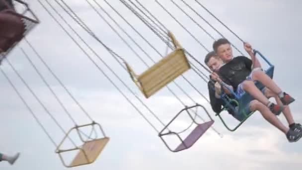 UKRAINE, TERNOPIL - July 20, 2018: Happy teenage best friends riding the chairoplane carousel and having fun at the funfair — Stock Video