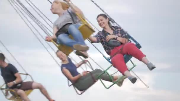 UKRAINE, TERNOPIL - 20 juillet 2018 : Meilleurs amis adolescents heureux chevauchant le carrousel de chairoplane et s'amusant à la fête foraine — Video