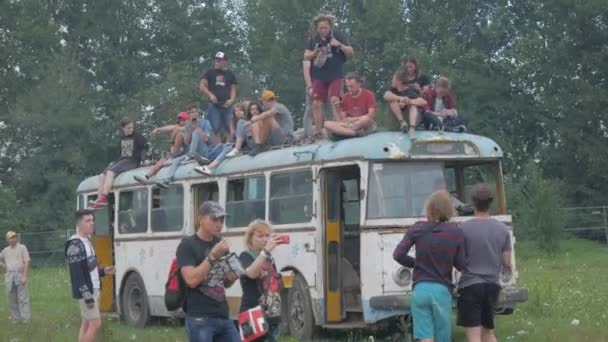 УКРАИНА, ТЕРНОПИЛ - 20 июля 2018 года: Молодая толпа подростков танцует на музыкальном фестивале летом на старом ретро-троллейбусе — стоковое видео