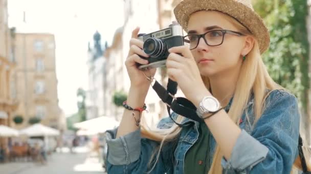 Τουριστική νεαρή γυναίκα παίρνει μια εικόνα κάμερας ρετρό μιας πόλης για διακοπές — Αρχείο Βίντεο