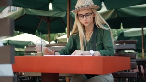 Mujer joven turista que explora el mapa de lviv en la cafetería y la bebida mientras viaja en Ucrania, concepto de vacaciones — Vídeo de stock