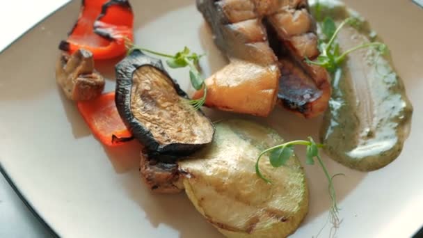 Refeições prontas do chef de um pedaço de peixe de salmão, legumes assados e costelas em um prato em um restaurante. conceito de pratos de cozinha passo a passo — Vídeo de Stock