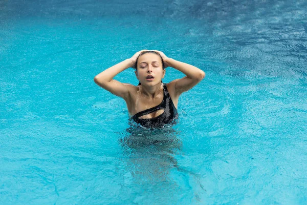 Islak seksi blackhair kadın havuzda poz mayo