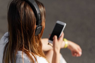 Kaldırımda oturan kız müzik dinleme