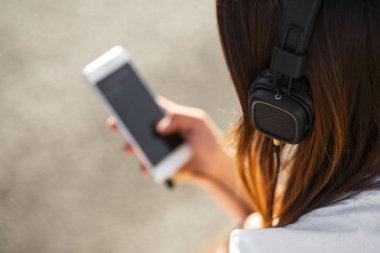 Kaldırımda oturan kız müzik dinleme