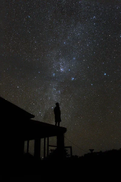 只有一个女人站在屋顶上 看着美丽的道路和巴厘岛夜空中的星星 — 图库照片