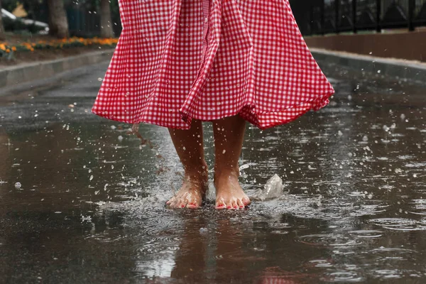 夏雨の後水たまりで踊る女の子の足のクローズ アップ — ストック写真