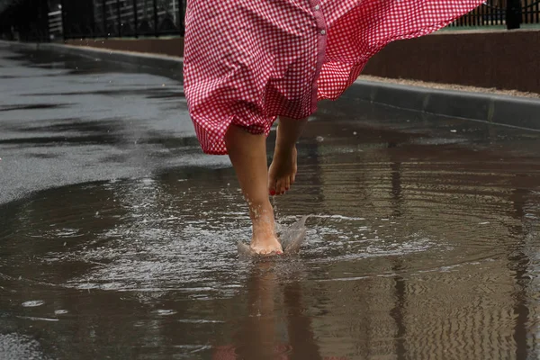 夏雨の後水たまりで踊る女の子の足のクローズ アップ — ストック写真