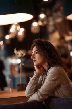 bir gri örgü kazak soğuk sonbahar rahat bir sıcak kafede fotoğraf makinesinde reklam gülümseme poz güzel esmer.