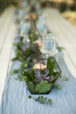 Taze sulu ve gül çiçekli Floraryum şenlik masası süslemesi. Olay taze çiçek süslemesi. Çiçekçi iş akışı. Düğün töreni tasarımı.