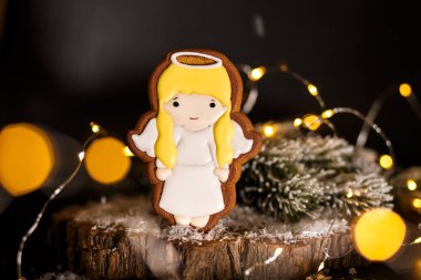 Tatil geleneksel gıda fırın. Garland ışıkları ile rahat dekorasyonda Gingerbread küçük şirin melek kız.