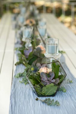 Taze sulu ve gül çiçekli Floraryum şenlik masası süslemesi. Olay taze çiçek süslemesi. Çiçekçi iş akışı. Düğün töreni tasarımı