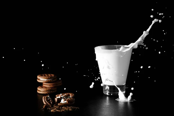 黒い背景にミルクとチョコレート クッキーのガラスでスプラッシュ — ストック写真
