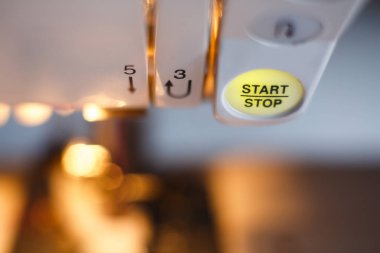 Dikiş makinesi düğmesine yakın çekim. İş yeri terzisi. Dikiş endüstrisi.