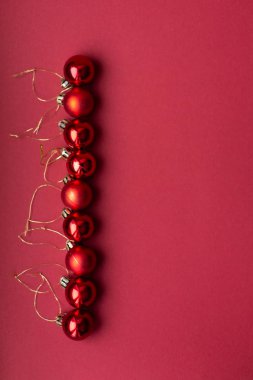 Kırmızı Noel ağacı dekoratif oyuncak top kırmızı kutlama Noel arka plan üzerinde dikey çizgi ortaya koydu. Yılbaşı tatil. Noel tatili.