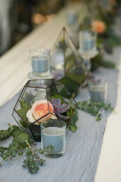 Florarium with fresh succulent and rose flowers festive table decoration. Event fresh flowers decoration. Florist workflow. Wedding banquet design