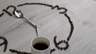 kahve içmek için zaman. Kahve çekirdekleri izle arama ahşap bir masa yerleştirilir. bir fincan kahve yerine 7 am've kaşık yerine okları izlemek