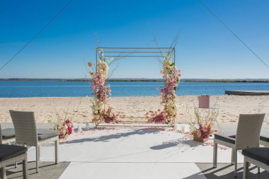 Olay dekorasyonu. Nehir kenarındaki düğün chuppa 'sı taze çiçeklerle süslenmiş. Çiçekçi iş akışı.